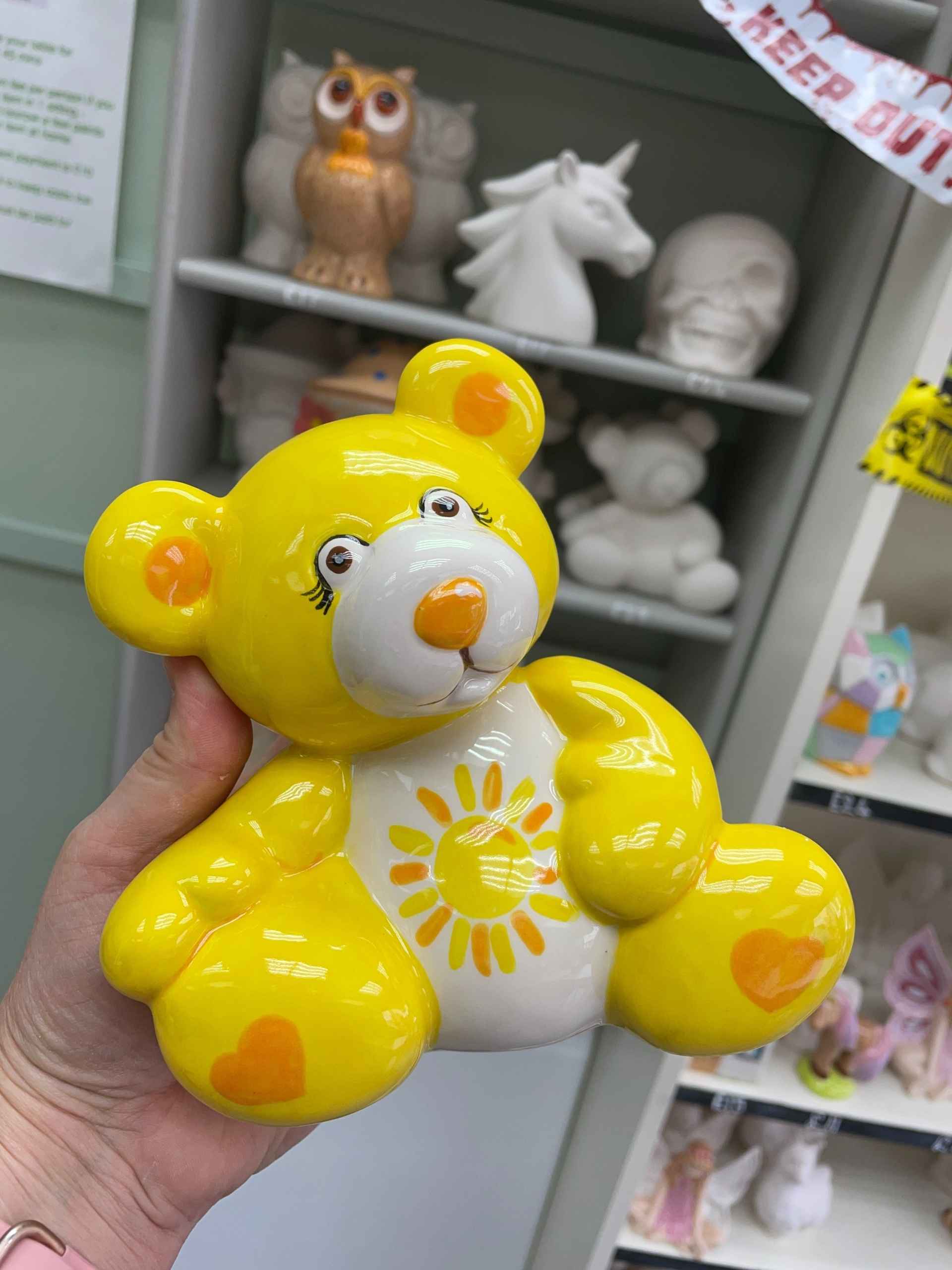 A charming yellow teddy bear-shaped pot, bringing a whimsical element to home decor.